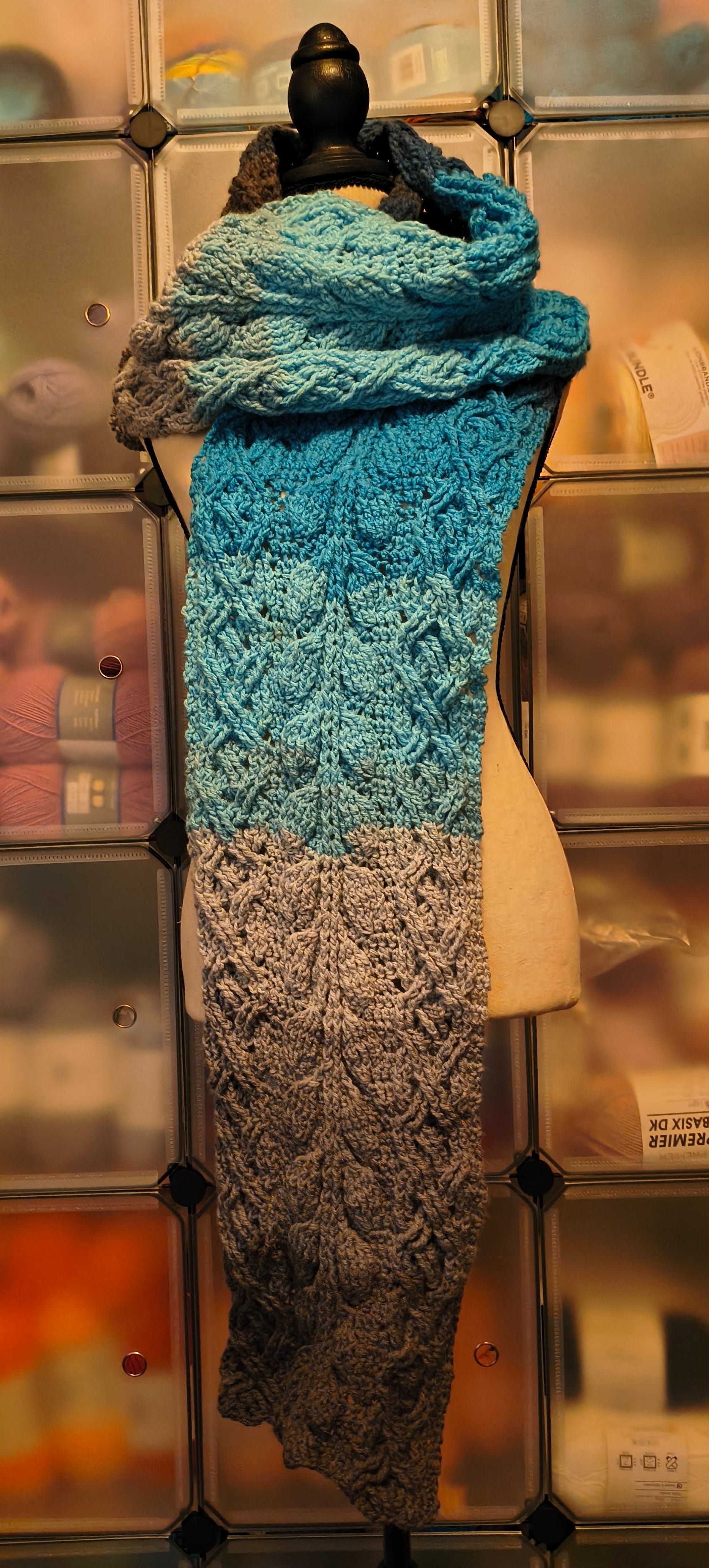 Handmade blue crocheted extra-long cabled scarf with gradient tones and leaf pattern texture