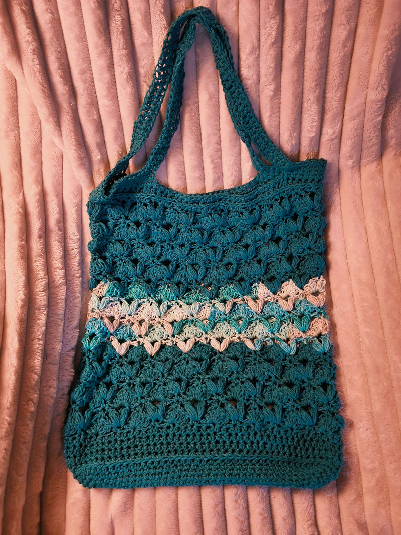 Purple and pink textured bag on beige blanket