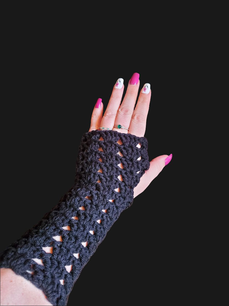 black crochet fingerless gloves worn on hand with textured stitch design