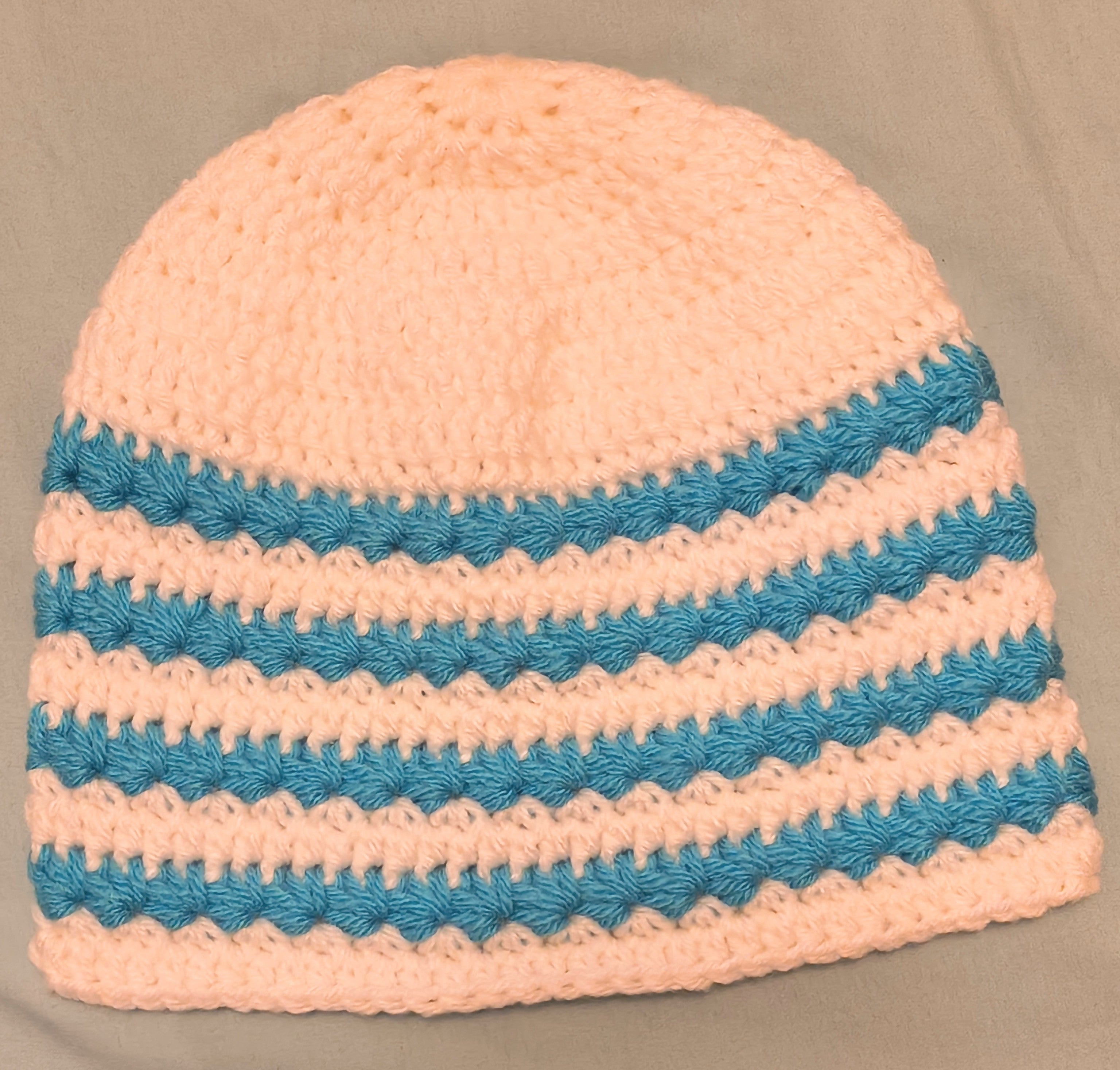 White and blue striped Star stitch beanie on plain surface