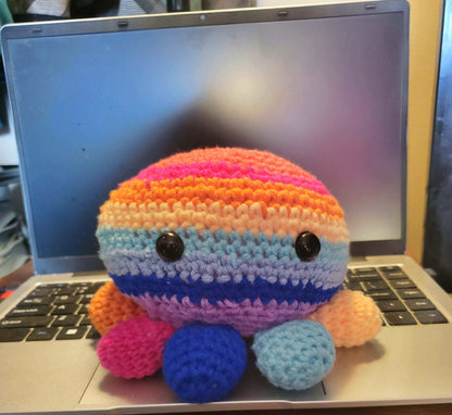 Handmade crocheted rainbow octopus toy with hidden compartment, featuring colorful stripes, safety eyes, and bright tentacles.