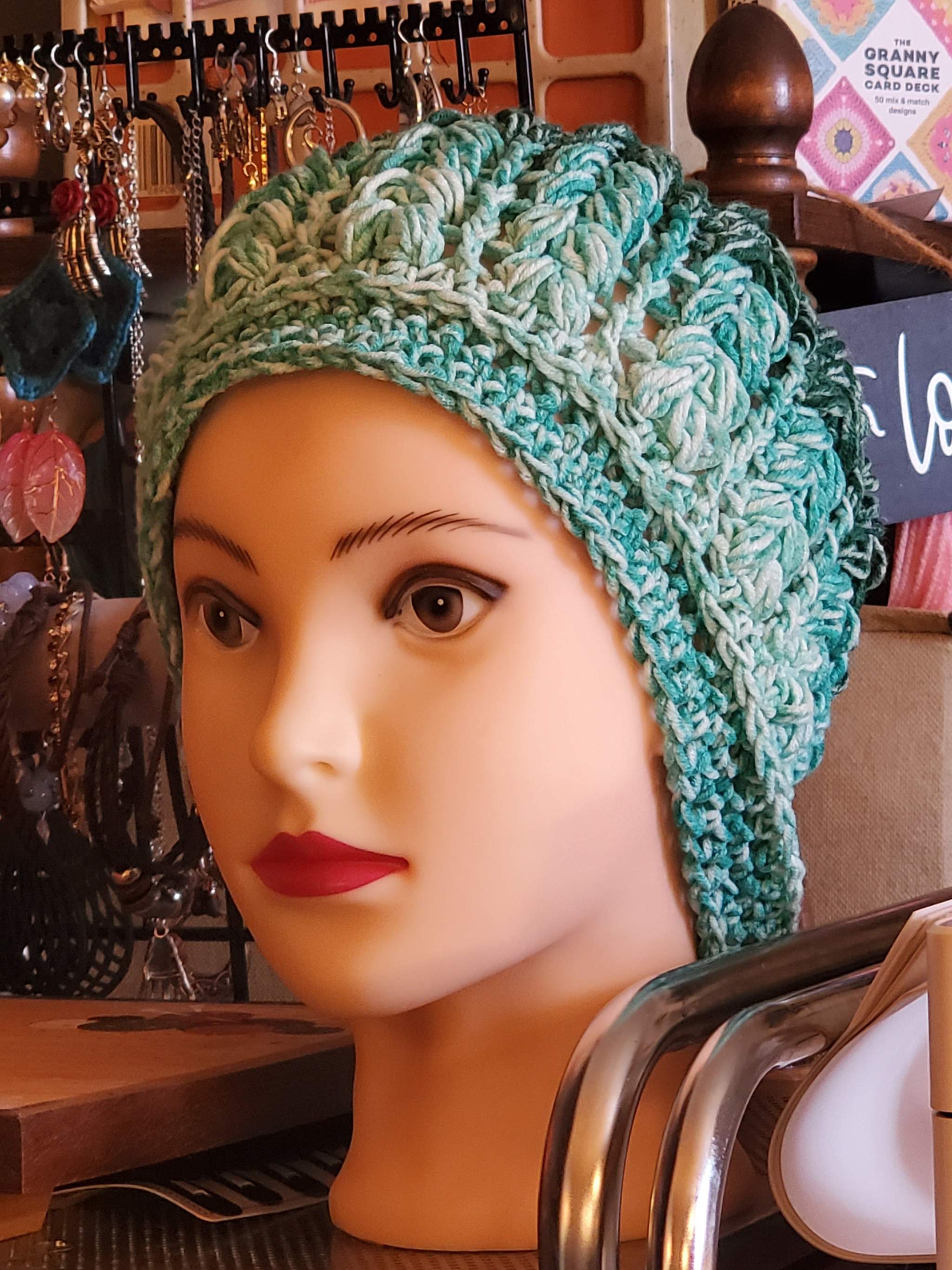 green ombre crochet beanie hat in teal and mint tones with lightweight textured stitch on mannequin head