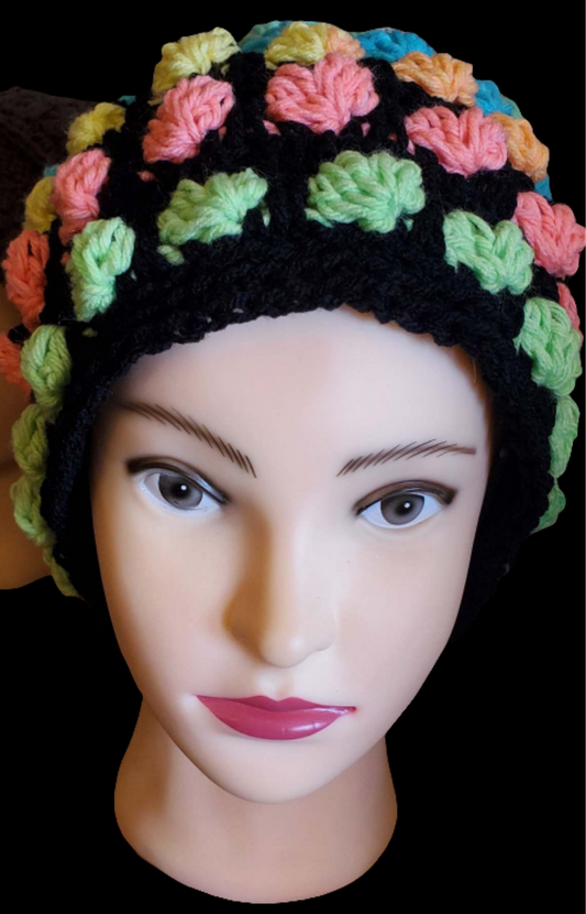Rainbow hearts hat with vibrant pattern on mannequin head.