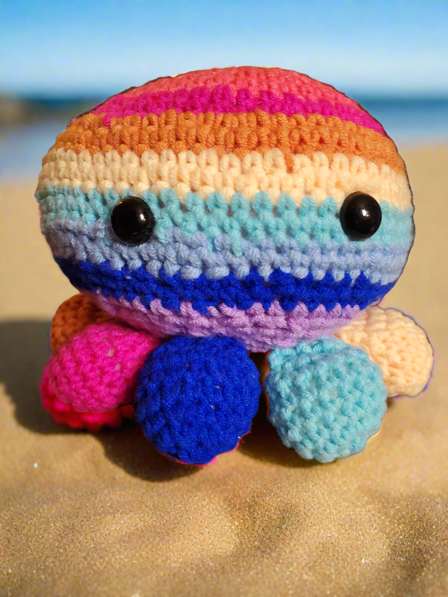 Handmade crocheted rainbow octopus toy with hidden compartment.