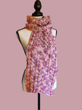 Handmade crochet scarf in soft pink, rose, and peach tones using 100% cotton yarn, featuring a detailed cabled stitch design with a slightly heavier, structured feel, displayed on a dress form.