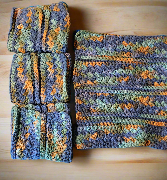 Set of 4 variegated dishcloths in dark blue, green, and brown hues.