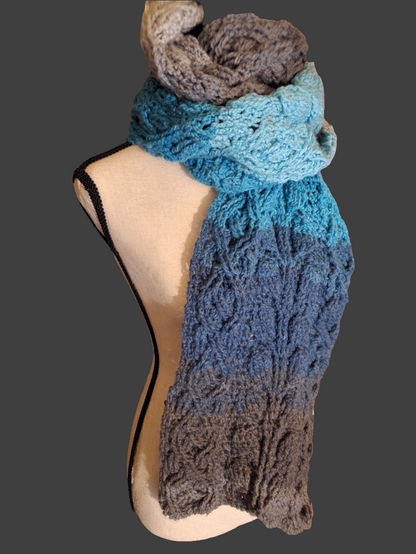 Handmade crochet leaf cable scarf in blue, teal, and gray gradient, long textured winter scarf with intricate leaf stitch pattern displayed on mannequin