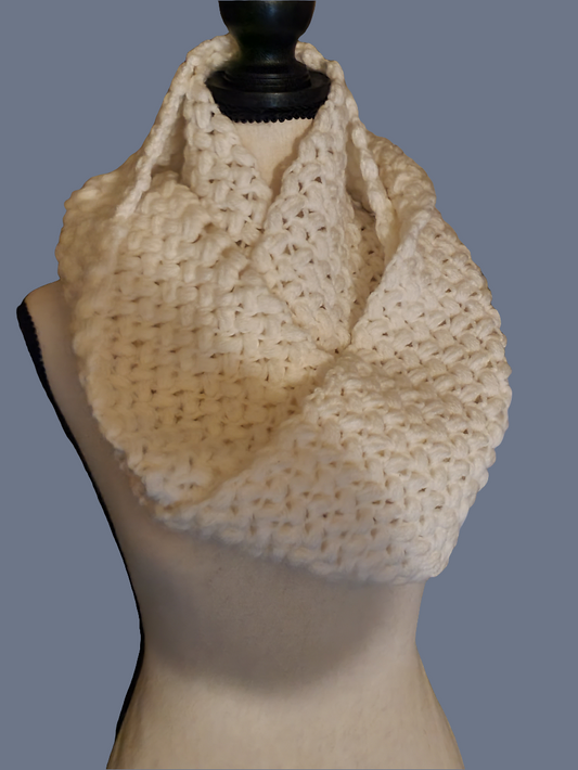 Handmade crochet chunky cowl scarf in soft off-white with dense puff stitch texture, long and oversized for extra warmth, wrapped around a dress form.