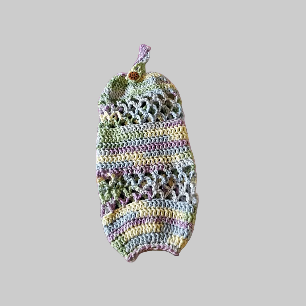 Handmade crocheted acrylic plastic bag holder on vibrant floral background.