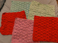 Handmade set of five cotton puff stitch washcloths in red, aqua, light aqua, and pink, arranged together showing thick textured design, approximately 10x10 inches each