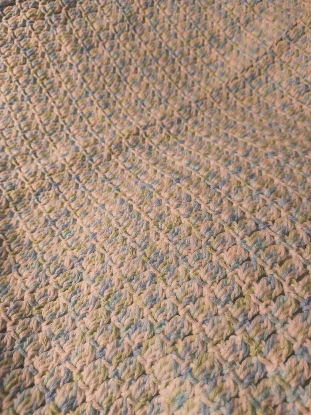 Close-up of blue green and white crochet baby blanket showing detailed textured stitches and soft lightweight yarn perfect for newborns