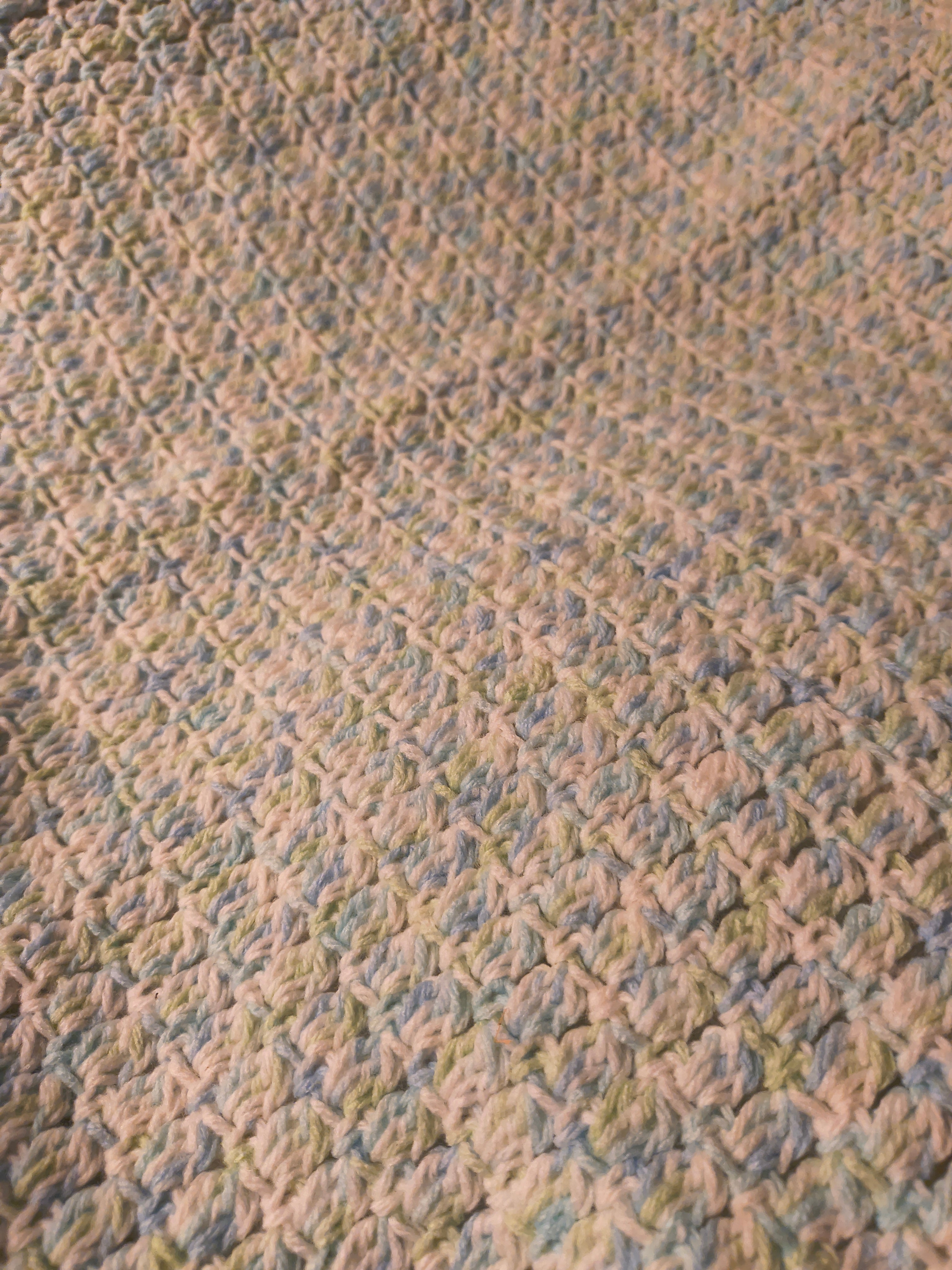 Close-up of blue green and white crochet baby blanket showing detailed textured stitches and soft lightweight yarn perfect for newborns