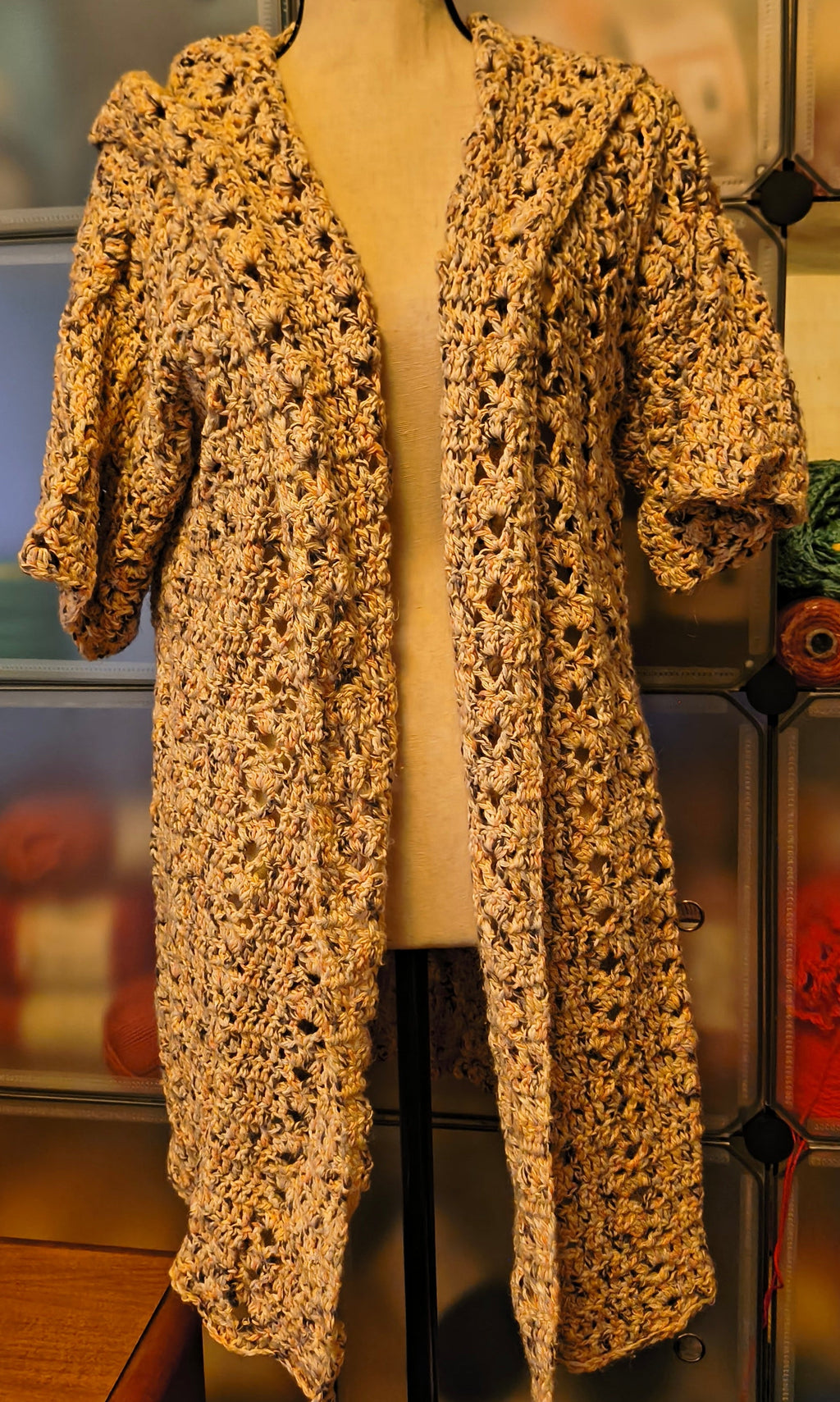 Handmade crochet hooded cardigan in soft neutral speckled cotton yarn, featuring an open front design, textured stitch pattern, and relaxed XL fit
