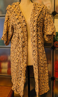 Handmade crochet hooded cardigan in soft neutral speckled cotton yarn, featuring an open front design, textured stitch pattern, and relaxed XL fit