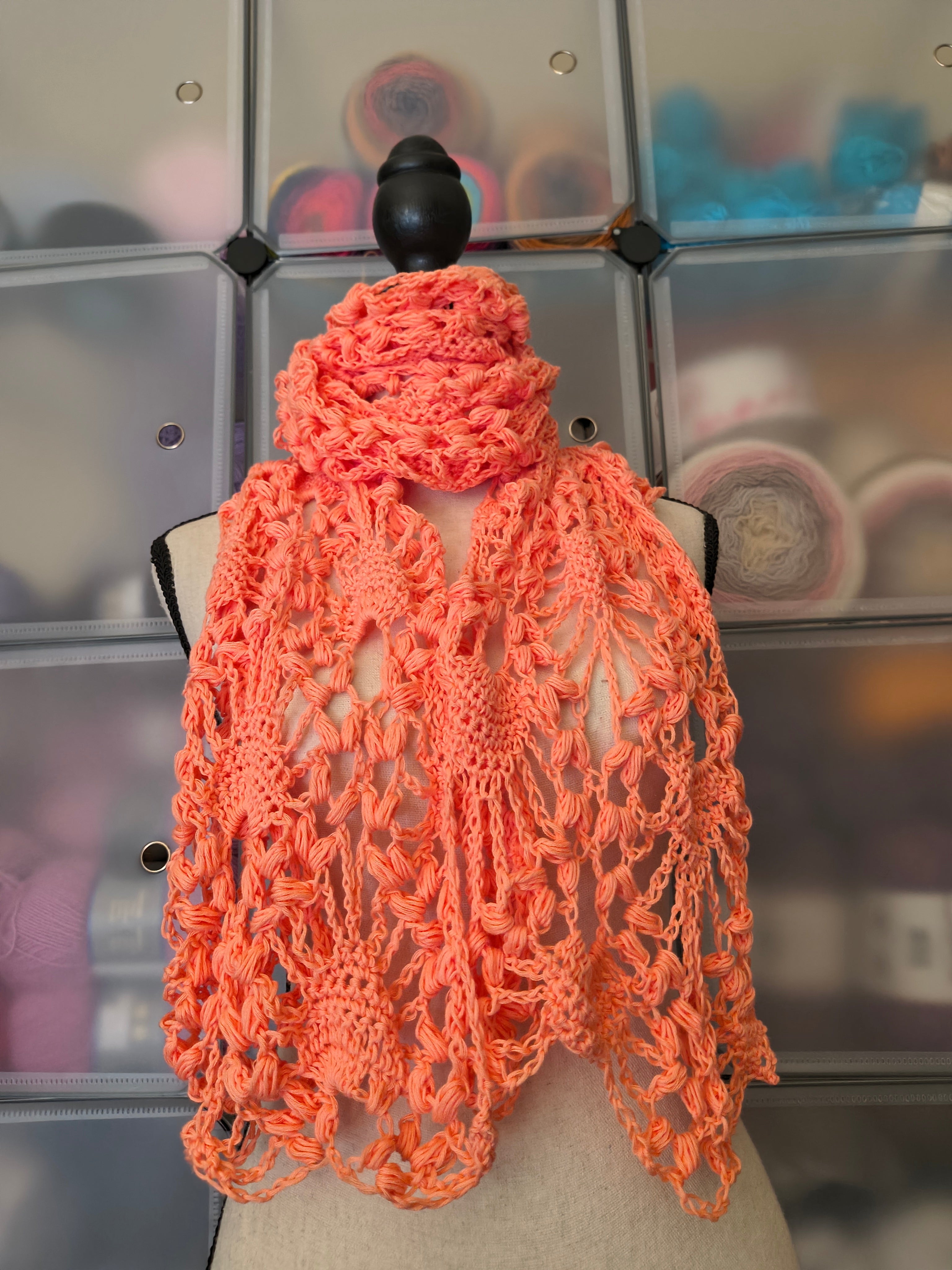 Coral crochet super scarf wrapped around a mannequin neck with flowing lace ends.