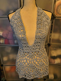 Handmade light silvery blue crochet halter top displayed on a dress form, featuring a deep V-neckline, intricate lace skirt, and adjustable open-back design.