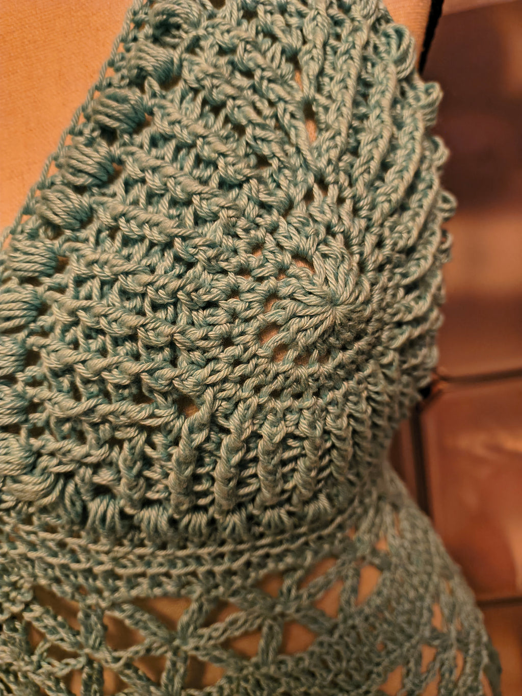 Close-up of textured light blue crochet cup with puff stitch border, showing detailed stitch work and dimensional design