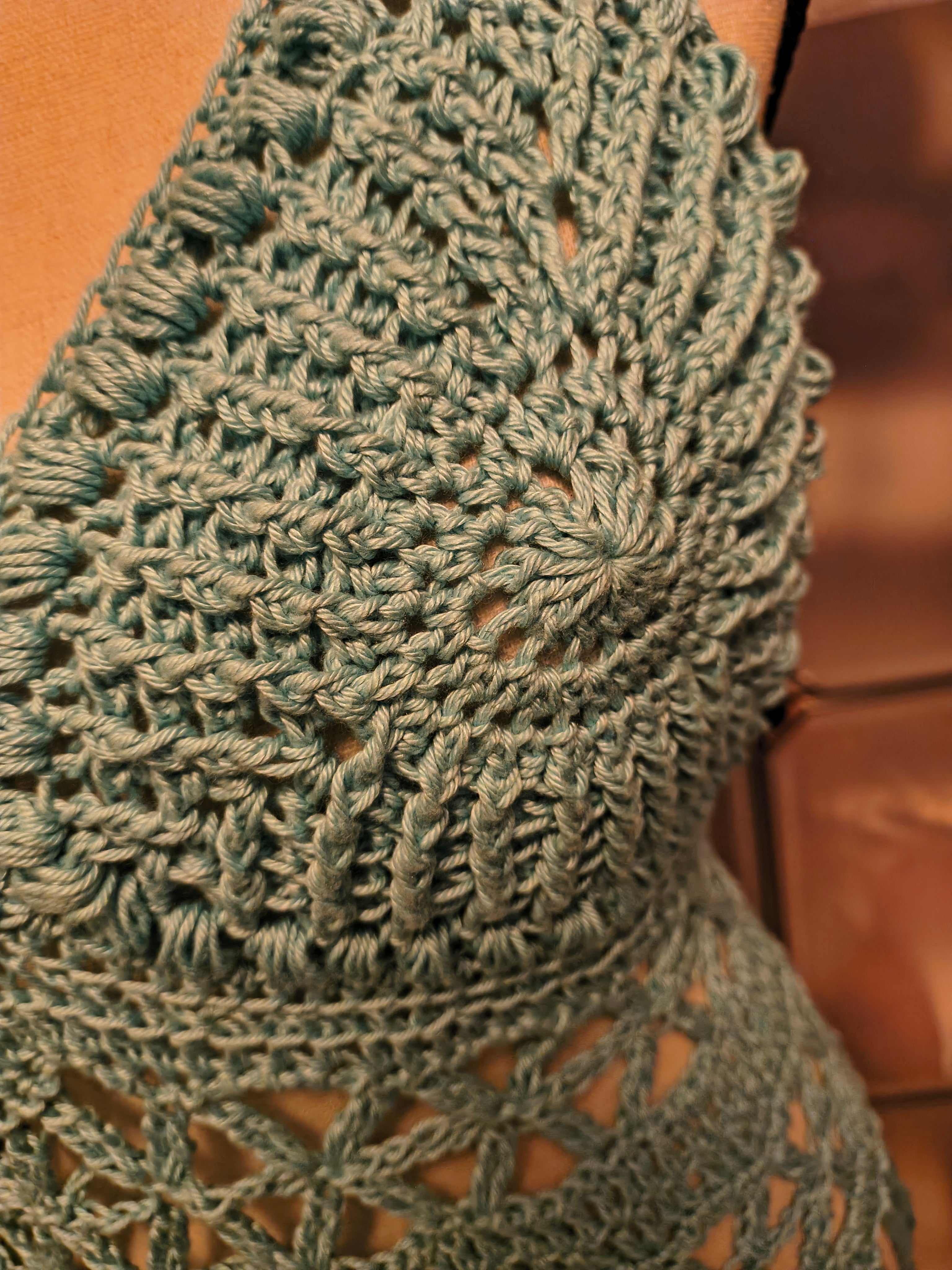 Close-up of textured light blue crochet cup with puff stitch border, showing detailed stitch work and dimensional design