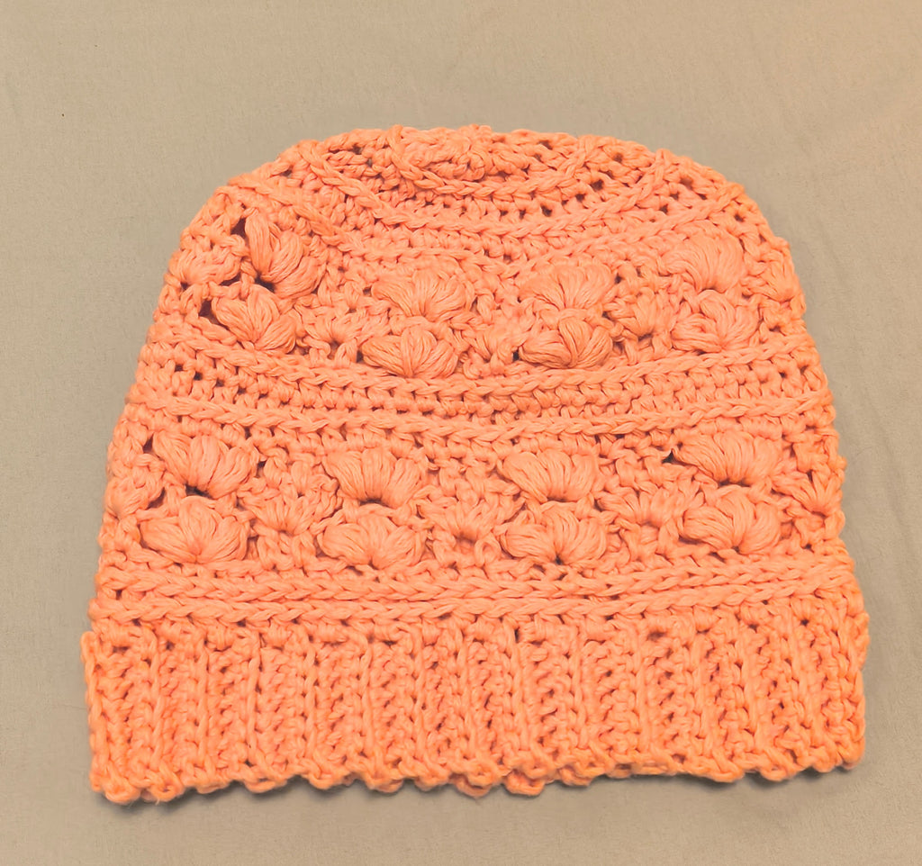 Peach crochet beanie made with cotton blend yarn, lightweight textured handmade hat laid flat on a neutral background