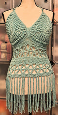 Light blue handmade crochet halter top displayed on mannequin, featuring textured triangle cups with puff stitch border, flower of life lace band, and long fringe detail