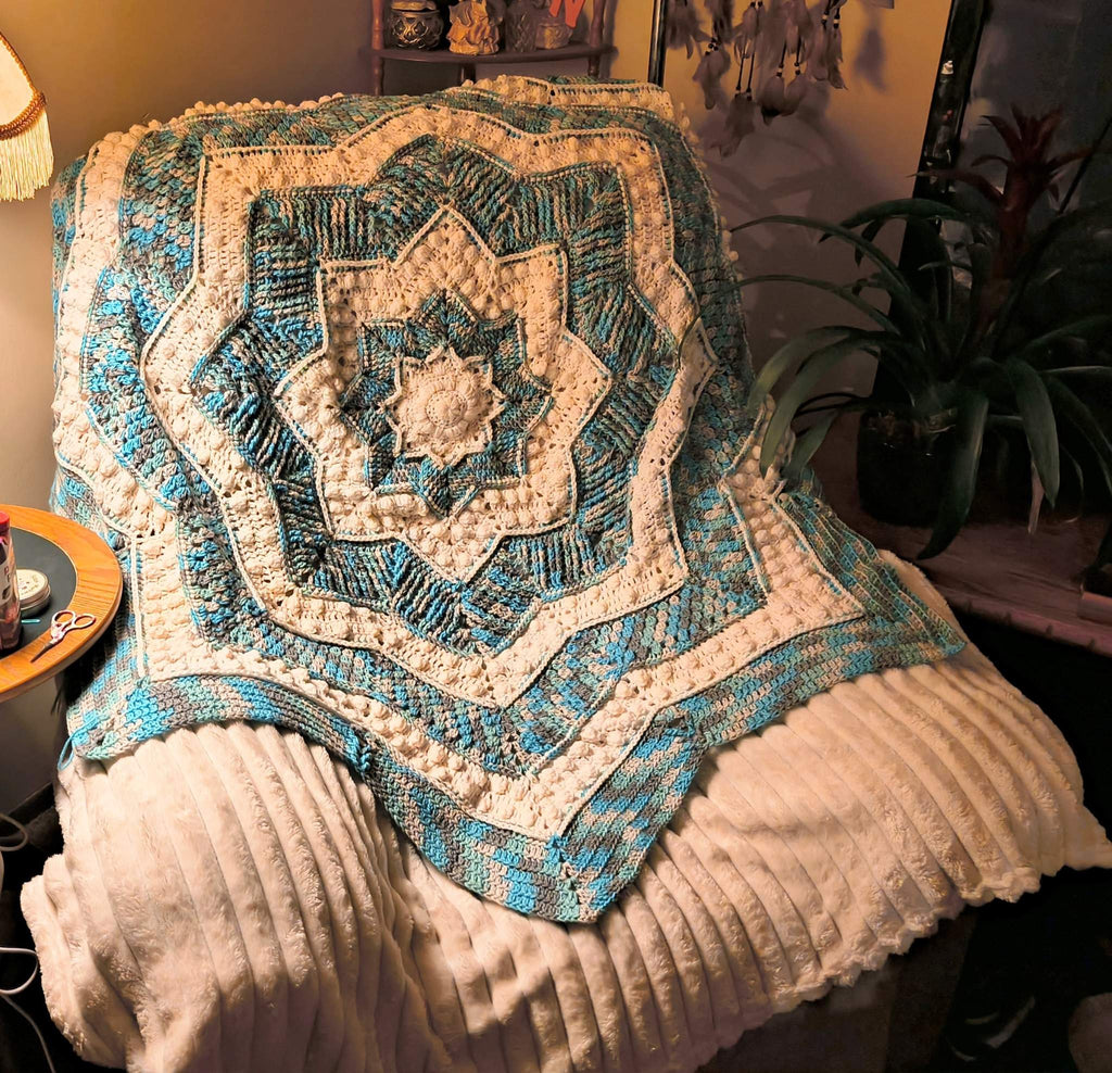 Handmade crochet star blanket in blue, gray, white, and camo tones featuring a mandala-inspired design and pointed edges, approximately 55 inches tip to tip